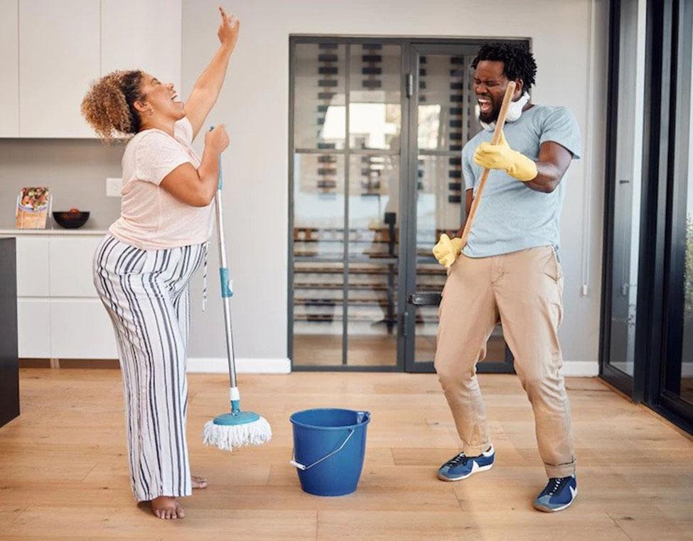 Couples enjoying while Cleaning their apartment